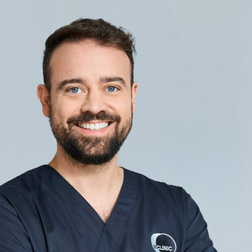Lächelnder Mann in dunklem medizinischem Kittel